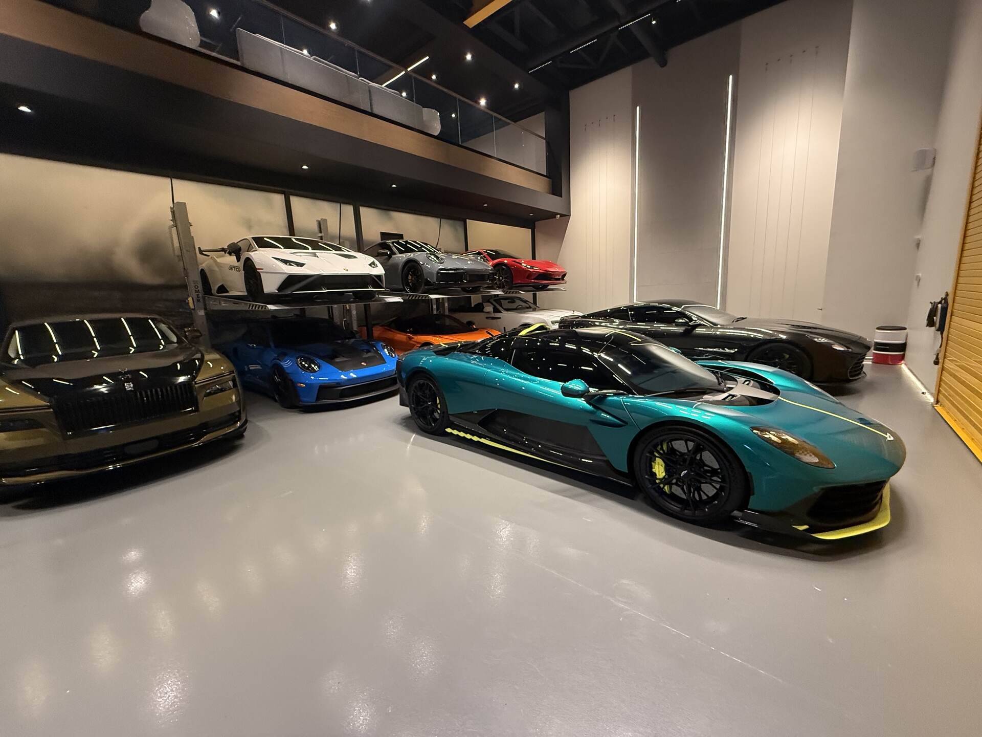 Aston Martin Valhalla and Rolls-Royce Spectre inside the garage at night